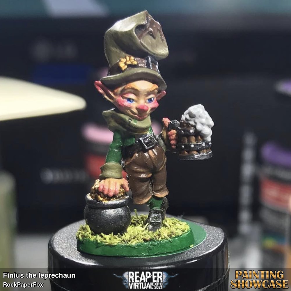 A merry leprechaun ready to party and cause some mischief. 
Painted with craftsmart multisurface acrylics, his skin is a dark to light skin tone technique, with a black base coat for his clothing and various color layering, with basic light green grass turfing for his base.